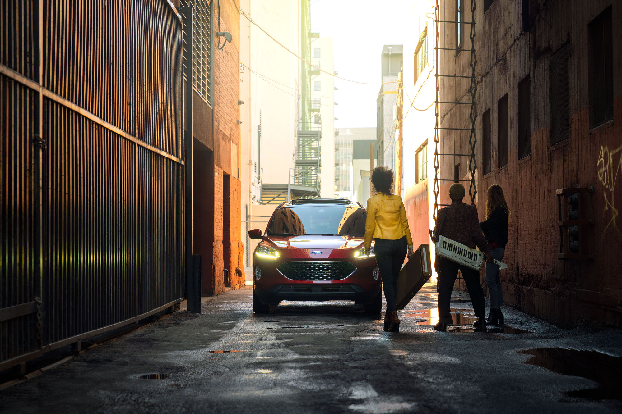 Band members jumping in a red 2020 Ford Escape in a downtown Los Angeles alley.
