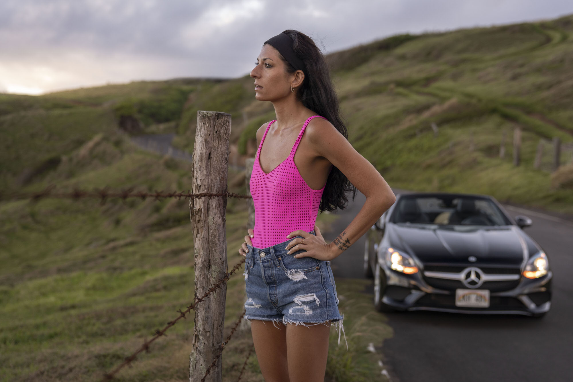 Chelsea Zerjav wearing her pink Acacia swimsuit on the Kahekili Highway driving the Mercedes-Benz SLC 300